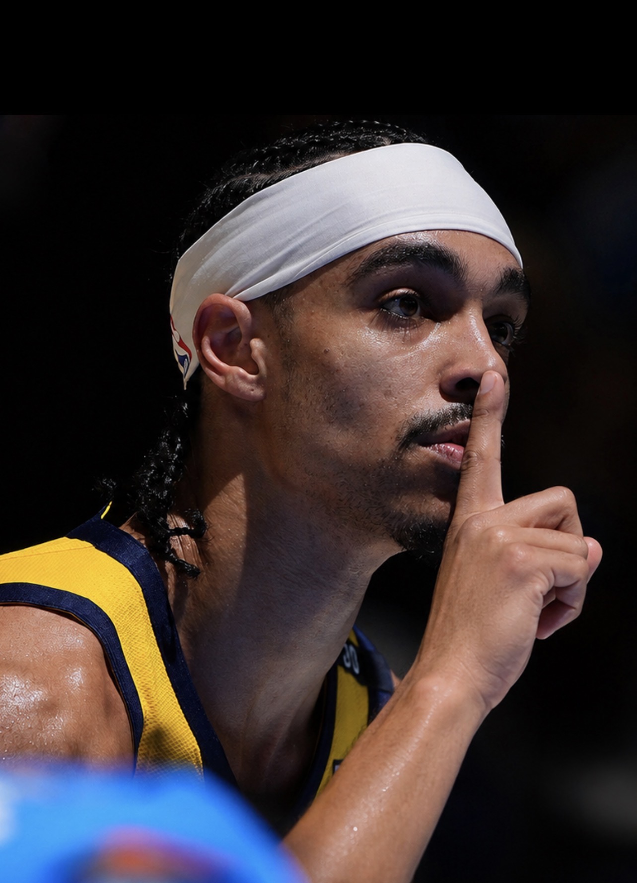 Close up of a player, eyes locked, finger to the lips